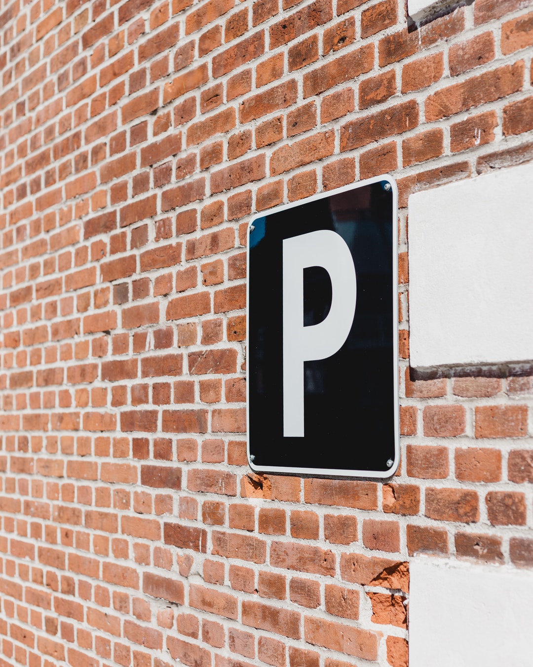 parking sign on brick wall